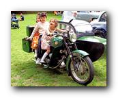 A couple sitting on a motorcycle

Description automatically generated with medium confidence